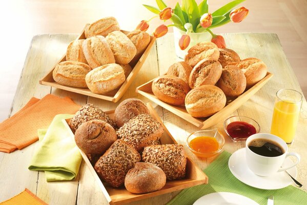 Sur la table sont des assiettes avec des petits pains et une tasse de café