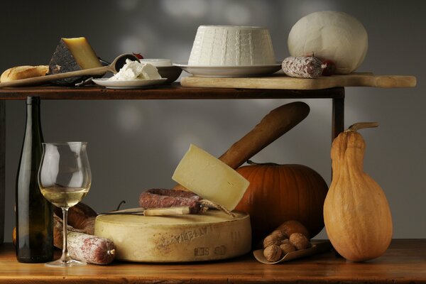 Naturaleza muerta de otoño con calabaza, vino, queso y nueces