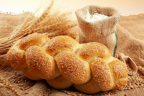 Sacchetto di farina accanto a pane e grano