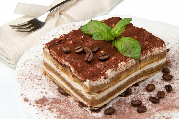 Tiramisú de postre en un plato. Decorado con granos de café