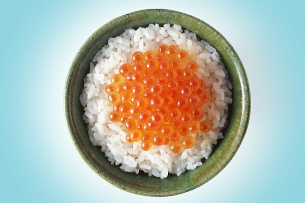 Arroz con caviar rojo en una taza verde