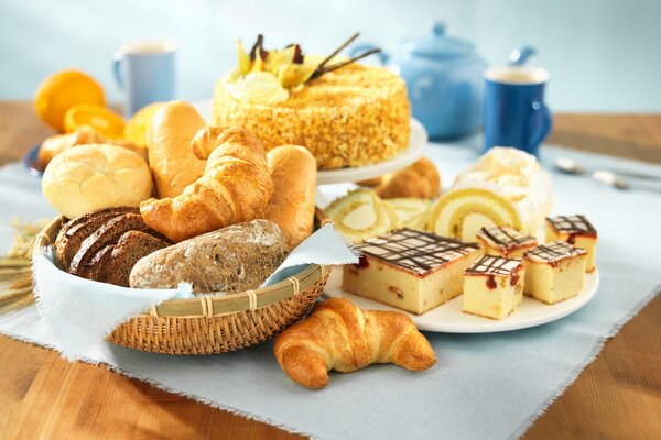 Frische Croissants, Kuchen und Zitronen mit Tee