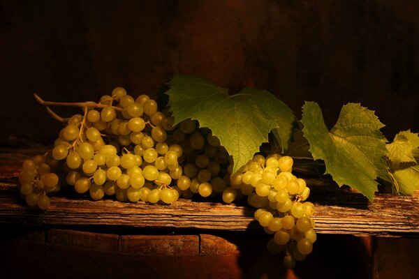 Racimos de uvas con hojas sobre la mesa