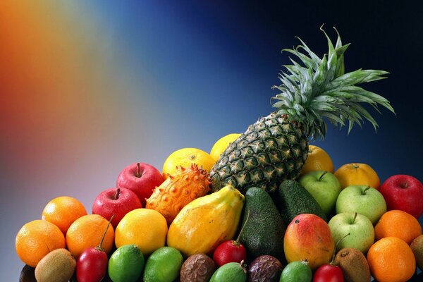 Assorted whole fruits: pineapple, apples, limes, lemons, oranges, kiwi