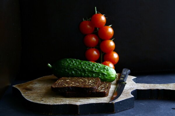 Pan negro con pepino y tomates en una tabla