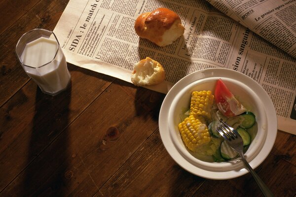 Snack salad, milk and nearby newspaper