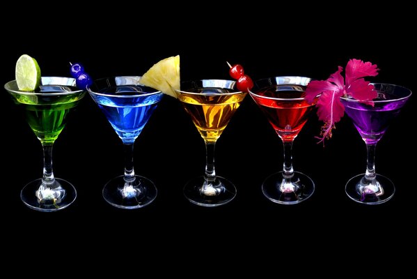 Colored cocktails with fruit on a black background