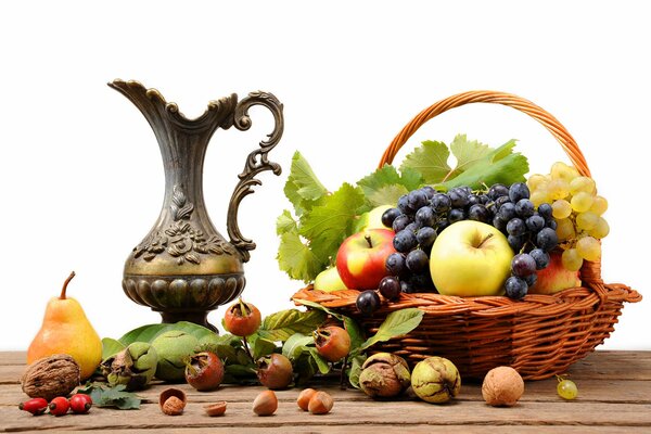 Still life consisting of a jug with a basket of fruit on a white background