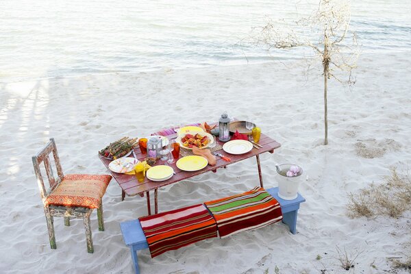 Gedeckter Tisch mit Leckereien am Strand