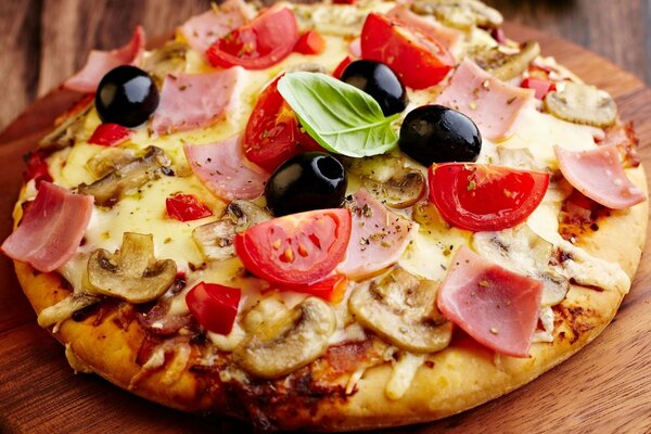 Pizza with ham, cheese, mushrooms and tomatoes