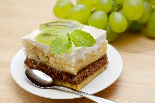 Ein Stück Kuchen auf einer Untertasse mit einem Minzblatt