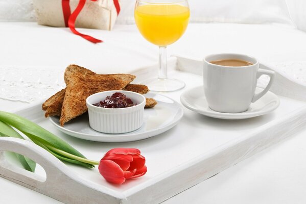 Frühstück am Morgen mit Toast und Marmelade, Saft und Kaffee auf einem Tablett