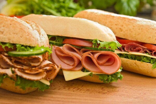 Sandwich with ham, fresh vegetables, lettuce and slices of cheese