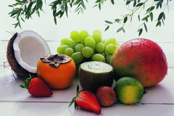 Delicious fruits are shown: coconut, strawberry, kiwi, persimmon and grapes