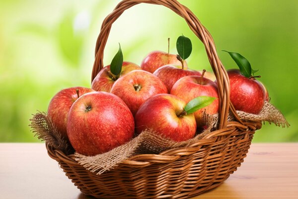 Wicker basket with red apples on the table