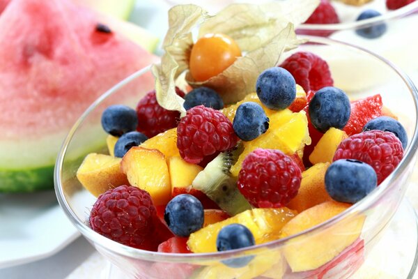 Ensalada de frutas y bayas en un tazón sobre la mesa