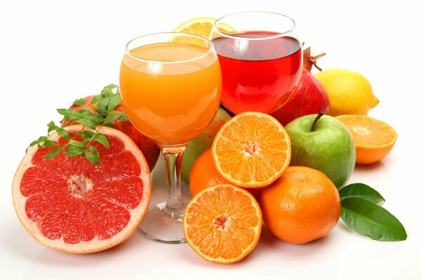 Glasses with juice among various fruits