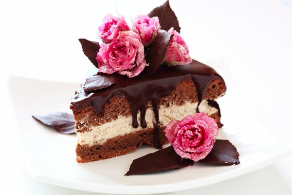 A piece of cake with cream, chocolate glaze and roses