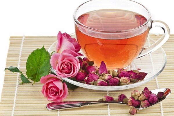 A cup of tea is strewn with pink roses