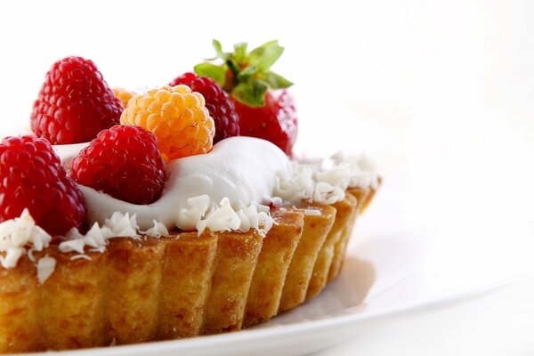 Kuchen mit Himbeeren, Erdbeeren und Sahne. Dessert auf einem Teller