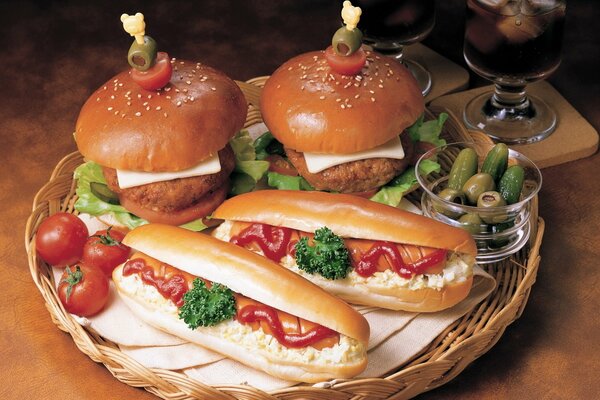 Hot dog and burgers on a plate with cola and olives