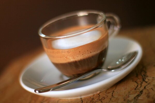 Café aromático con espuma en una taza transparente