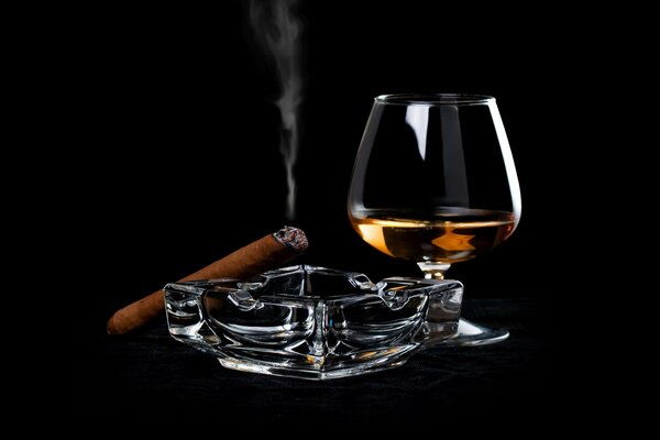 A glass of alcohol and an unlit cigar