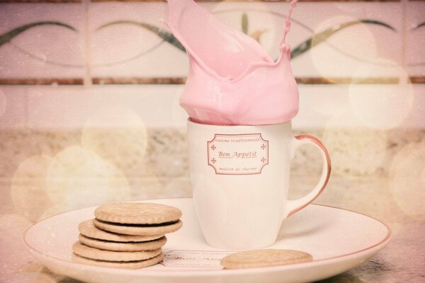 Cocktail rosa delicato in una tazza con biscotti per la colazione