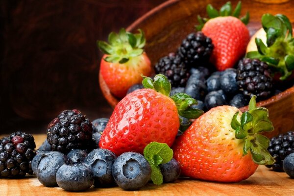 Bright berries spilled out of a wooden plate