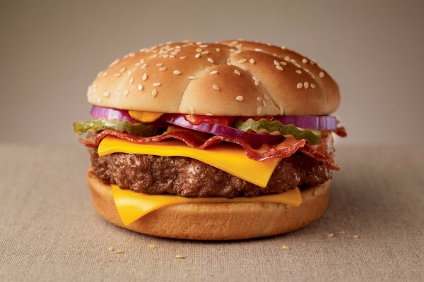 Cheeseburger mit Speck-Schnitzel mit Käsesauce und Gurke