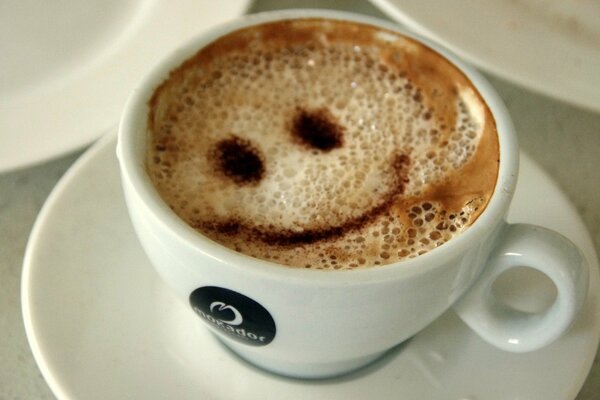 Smiley sonriente café en taza blanca