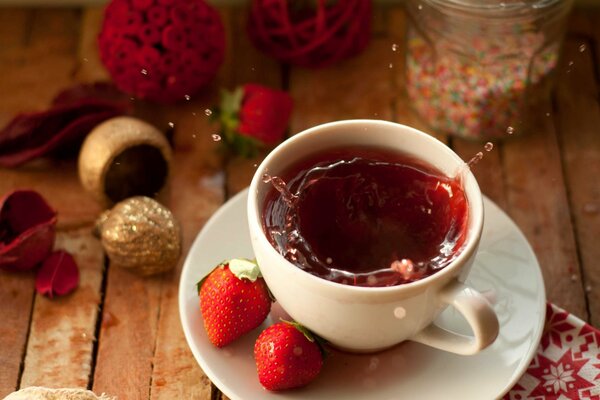 Salpicaduras de té de una taza. Fresa fragante