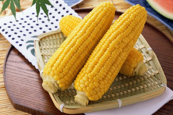Желтая кукуруза на плетёной тарелке