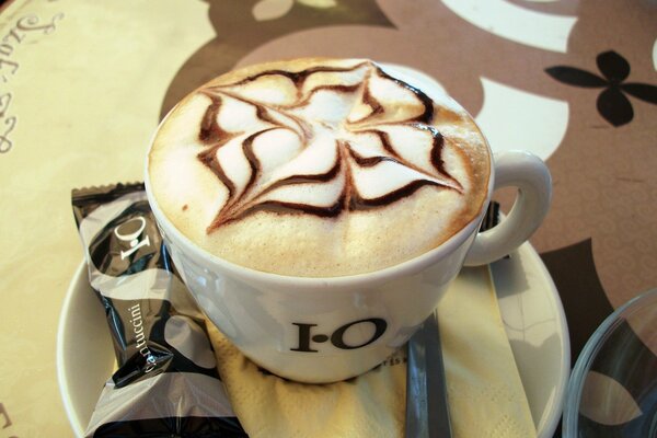 A cup of coffee with a pattern on the foam