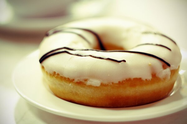 Donut in cream glaze on a saucer