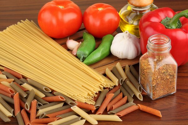 Stillleben aus bunten Fadennudeln mit Knoblauch und Pfeffer