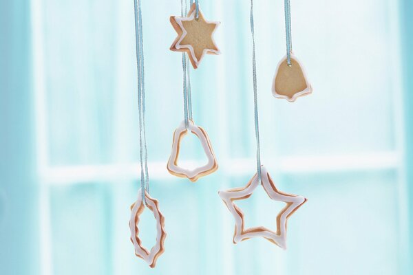 Biscuits de Noël sous la forme d étoiles et de cloches, suspendus sur des rubans