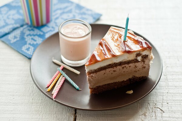 Pastel con velas y leche en un plato