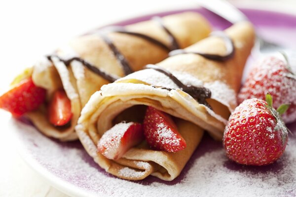 Pancakes with strawberries and powdered sugar