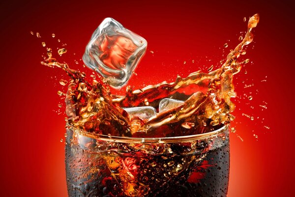 Spruzza Coca Cola da un bicchiere di ghiaccio