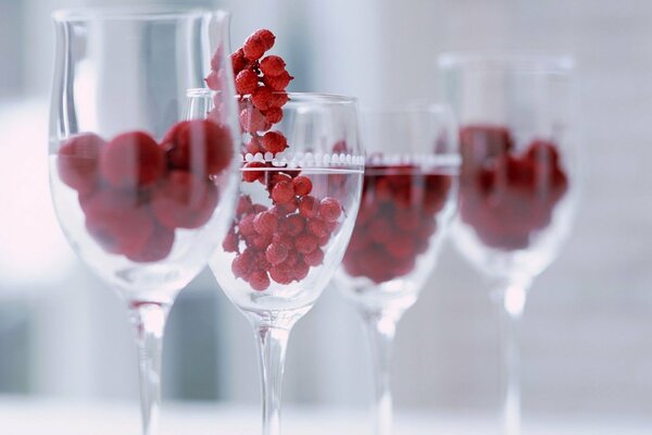 Four wine glasses containing rowan berries