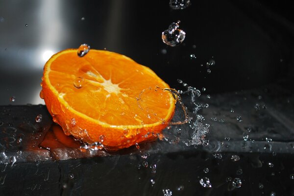 Naranja jugosa y cortada sobre un fondo oscuro