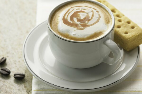 Kaffeetasse mit weißen Keksen auf Untertasse