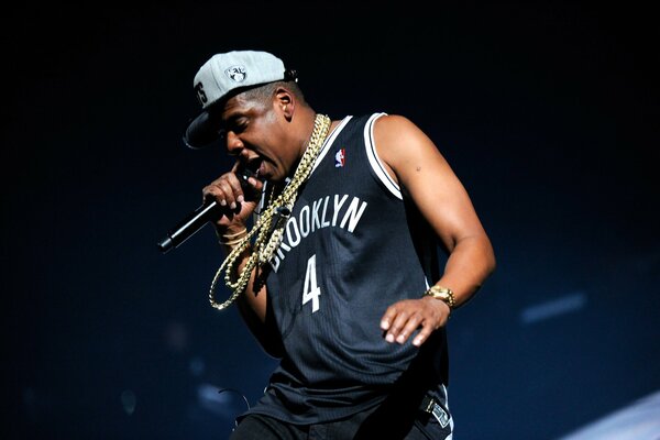 Jay-Z en camiseta negra y cadenas con micrófono R manos
