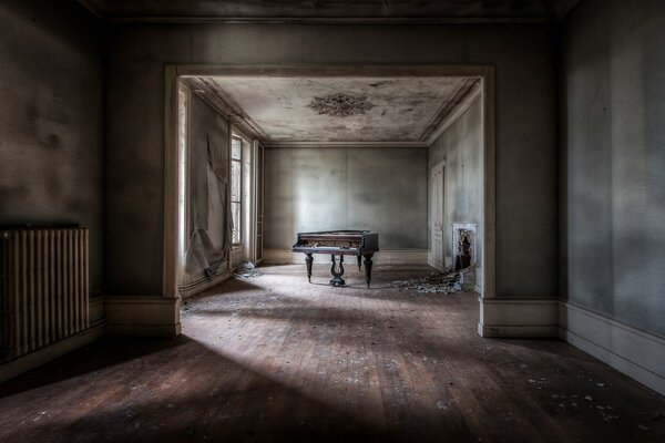 A dark room with a piano and a window