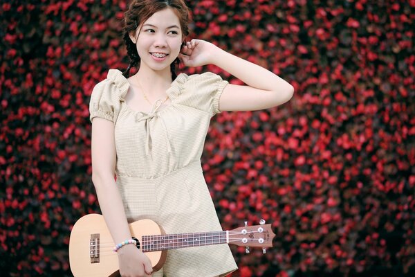 A smiling girl with a guitar in her hand