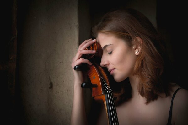 A young girl leaned against the cello