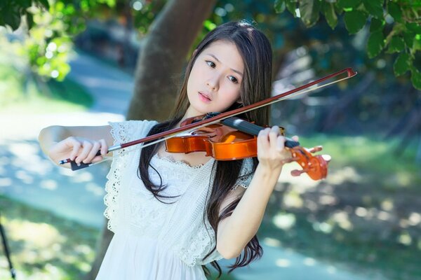 Chica tocando el violín en el Jardín