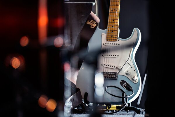 Guitarra azul contra luces borrosas