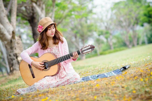 The girl in the hat plays the guitar